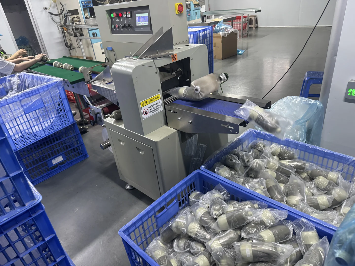 Bottles moving through protective bagging equipment