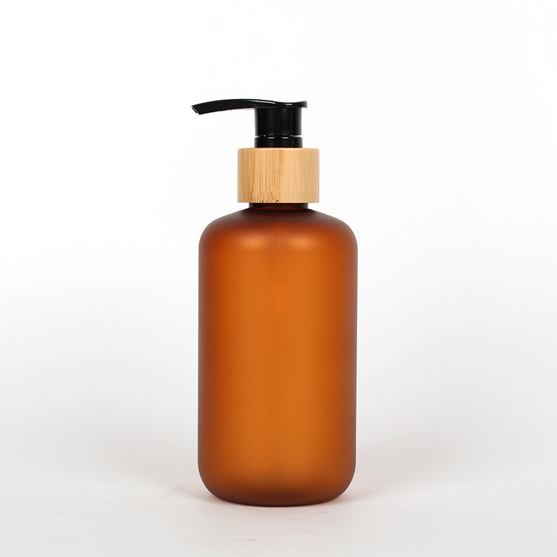 Amber-colored pump bottle with a black dispenser and wood-toned collar