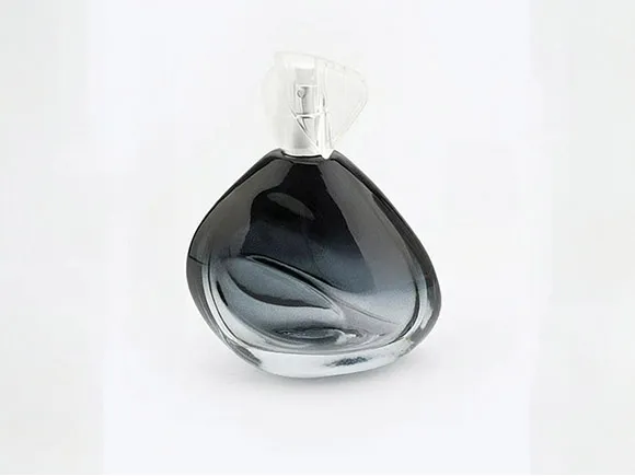 Sculptural dark perfume bottle with a curved profile and clear cap