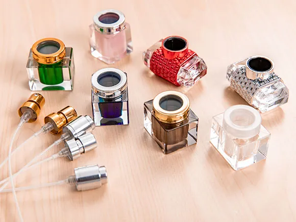 Decorative perfume caps beside sprayer components with dip tubes