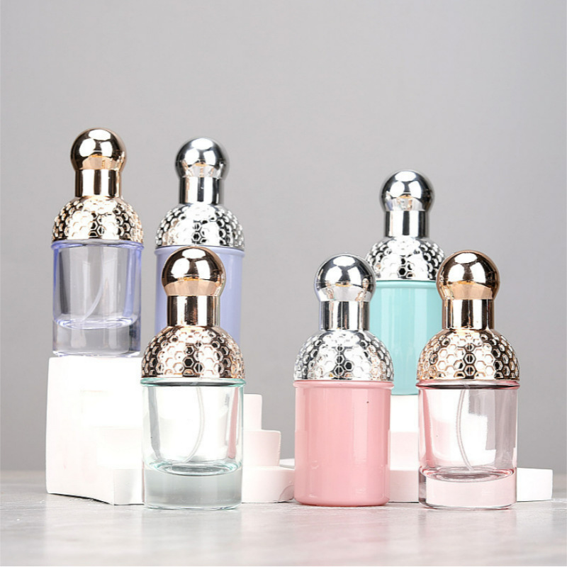 Small fragrance bottles in clear and colored finishes with metallic-looking tops